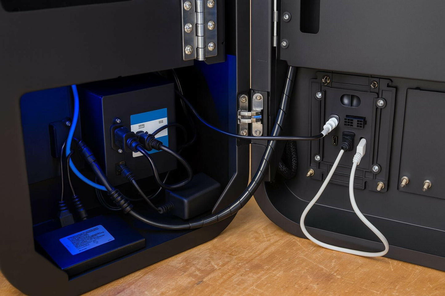 Internal view of VapeTM's smart vending machine showing wiring setup, power adapters, and communication ports connected to a KioSoft modem and accessory hub.