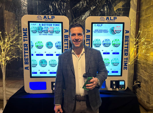 Jordan Brown, CEO of VTM Vending and VapeTM in front of two ALP nicotine pouch vending machines at Tucker Carlson party
