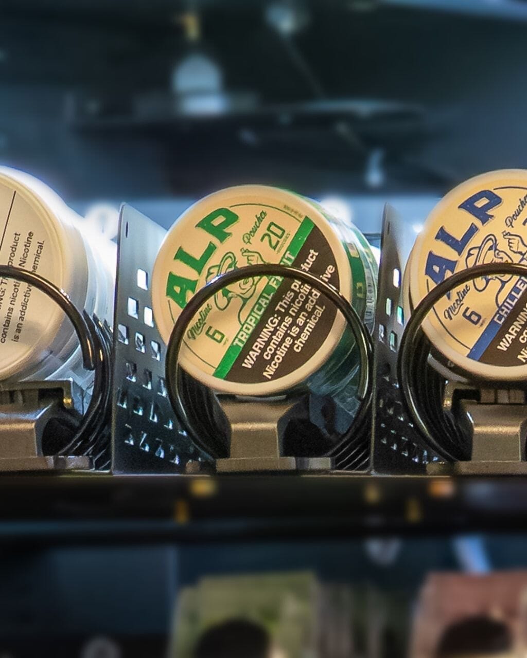 nicotine pouch tins and vape items organized with pouch lifter adapters